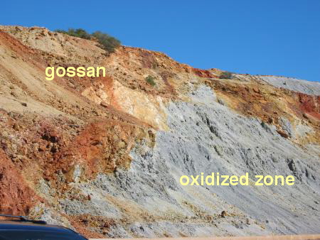 gossan - A rusty, surficial weathering zone which is caused by the oxidation of pyrite to produce secondary iron oxide minerals. Since pyrite is often associated with ore deposits, gossans can be a guide to 